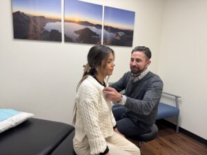 Naturopathic Doctor conducts exam and listens to a patient's chest/heart.