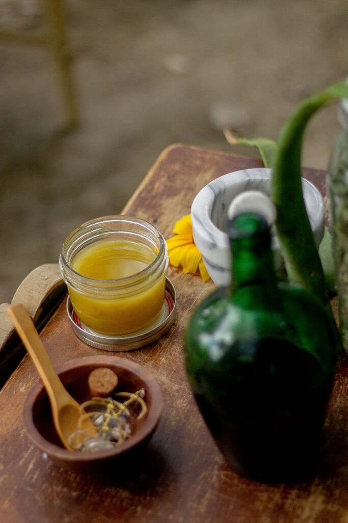 mortar and pestle alongside botanicals and a salve